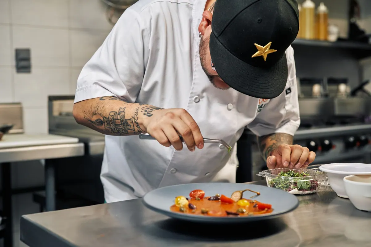 Chef dressant une assiette en cuisine Chef dressant une assiette en cuisine