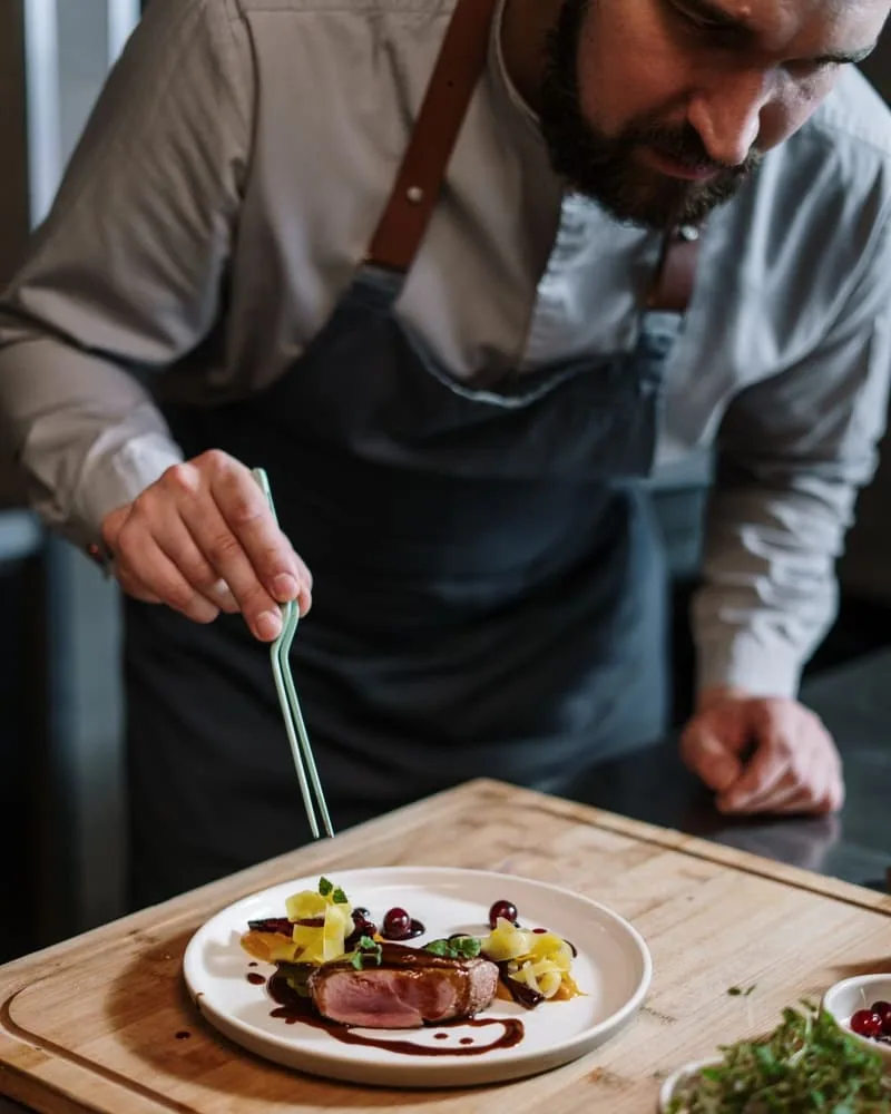 Chef dressant une assiette dans la cuisine de son restaurant (Restaurant)