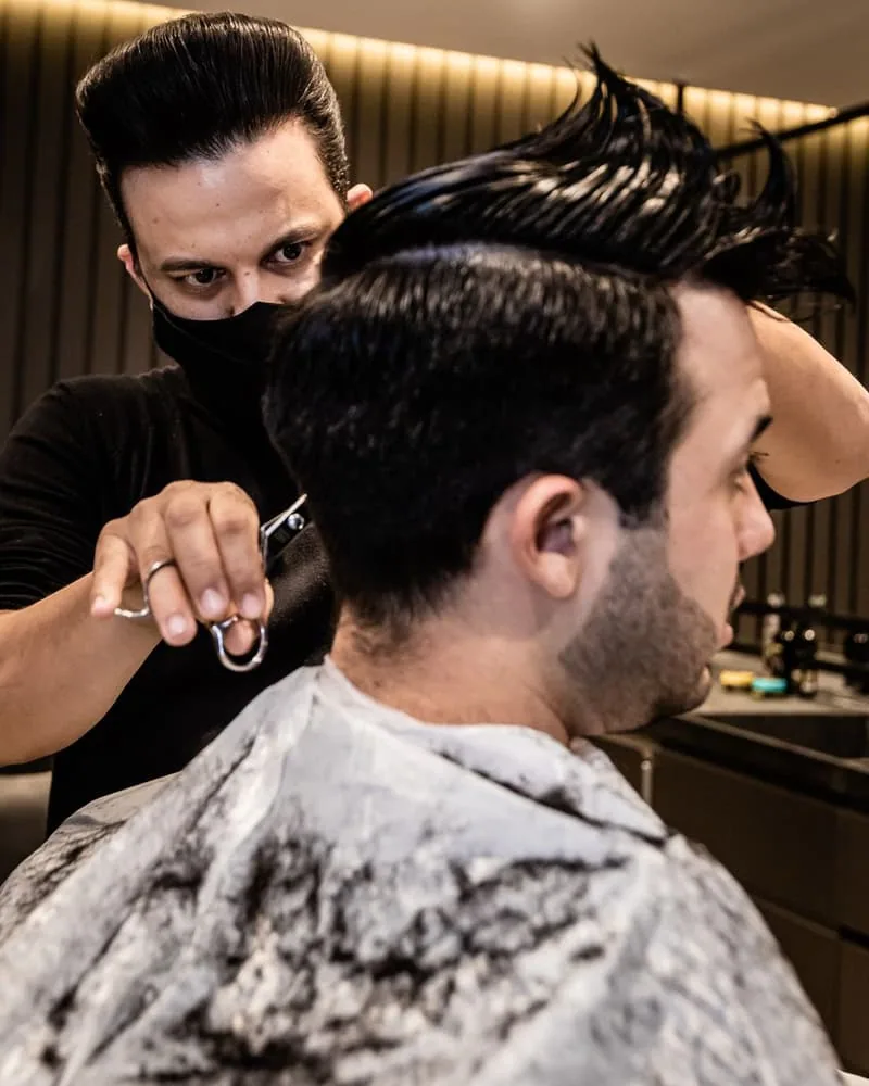 Coiffeur réalisant une coupe dans son salon (Beauté)