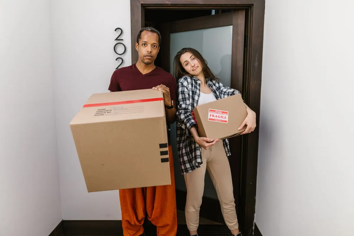 Couple portant des cartons de déménagement