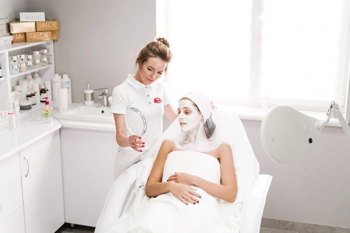 Esthéticienne réalisant un soin du visage en institut Esthéticienne réalisant un soin du visage en institut