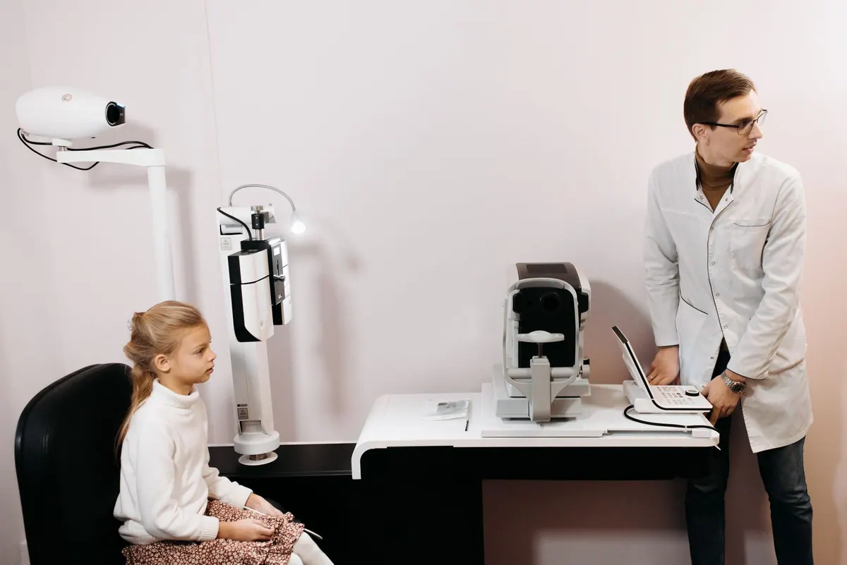 Examen de vue d’une enfant chez l’opticien Examen de vue d’une enfant chez l’opticien
