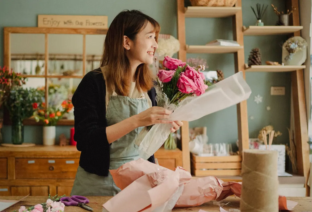 Fleuriste préparant un bouquet dans sa boutique