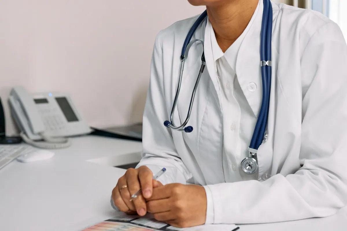 Médecin à son bureau, stéthoscope autour du cou