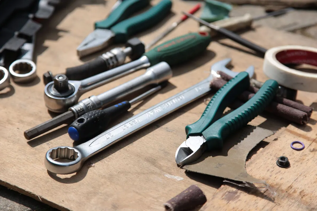 Clés, pinces et outils d’artisan posés sur un établi