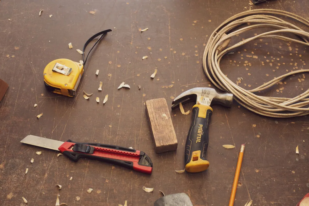 Marteau, mètre et cutter de menuisier sur un plan de travail Marteau, mètre et cutter de menuisier sur un plan de travail