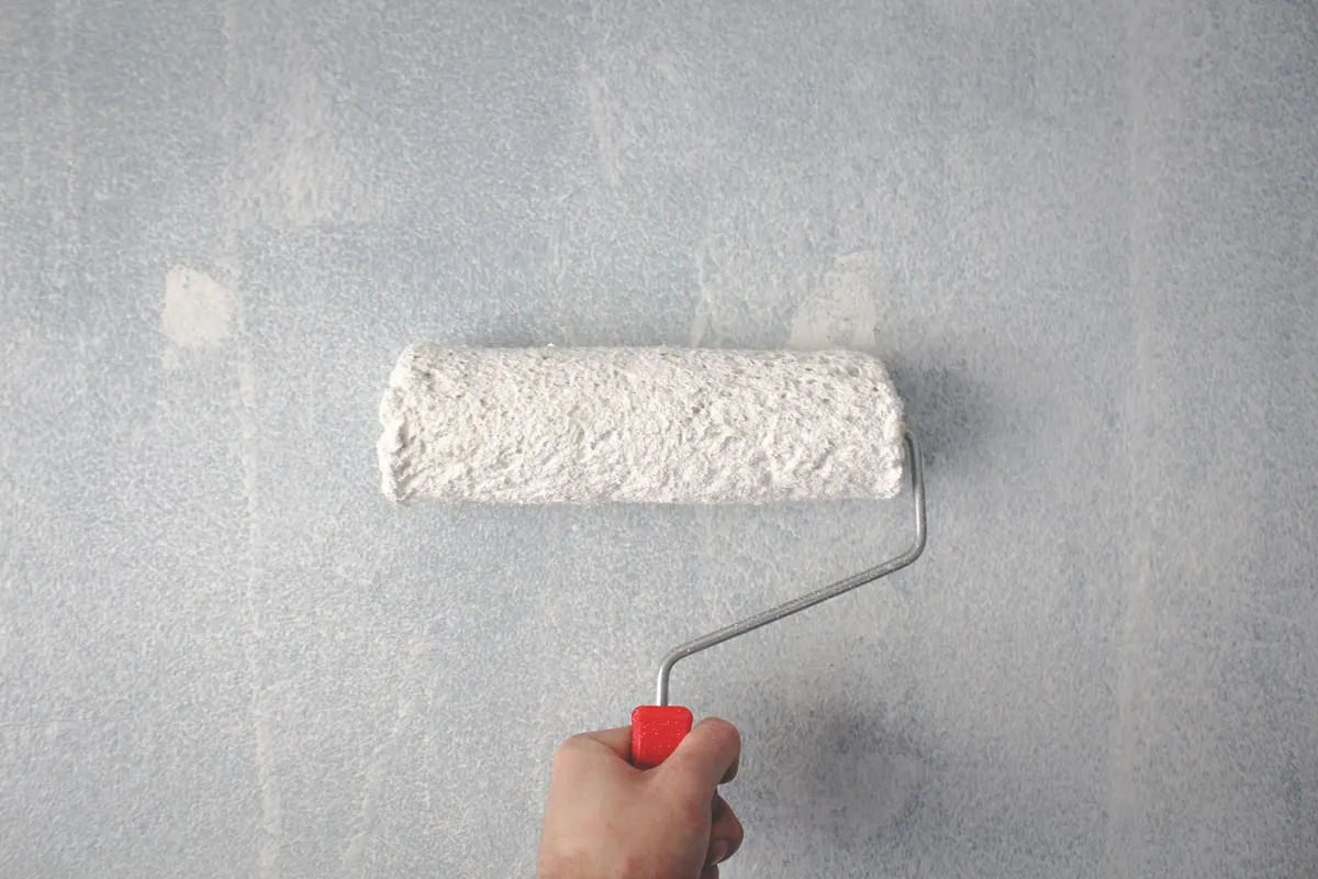 Rouleau de peinture sur un mur